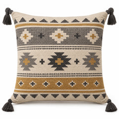 Neutral square cushion cover with geometric tribal stripe motifs and dark corner tassels