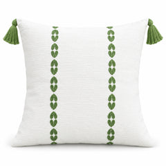 Ivory square cushion with two vertical rows of olive green tribal-style motifs and green corner tassels