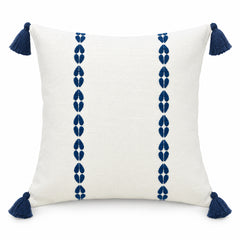 Ivory square cushion with twin vertical rows of navy blue motifs and blue corner tassels
