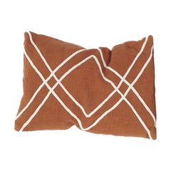 Brown pillow with white geometric pattern on a white background