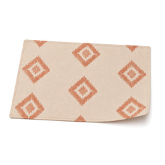 Ivory and terracotta ikat diamond placemat shown in a premium angled presentation, artisan table linen by Primeval