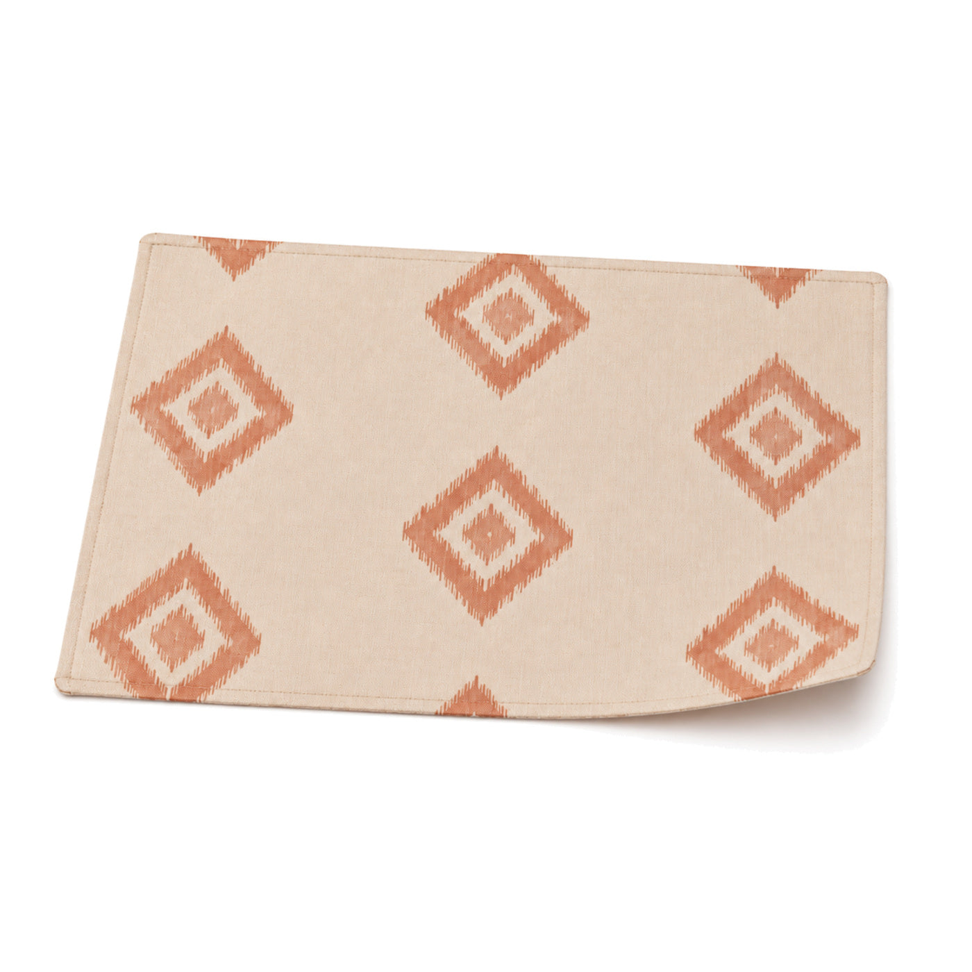 Ivory and terracotta ikat diamond placemat shown in a premium angled presentation, artisan table linen by Primeval