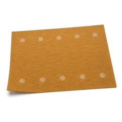 Mustard ochre embroidered rosette placemat shown in a premium angled presentation, artisan lightweight table linen by Primeval
