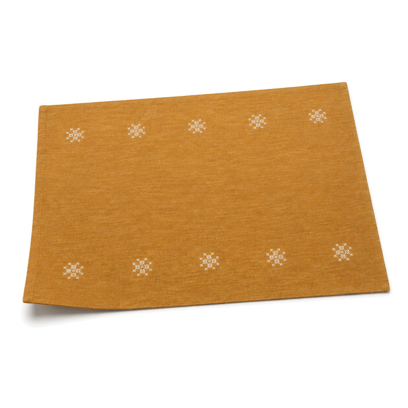 Mustard ochre embroidered rosette placemat shown in a premium angled presentation, artisan lightweight table linen by Primeval
