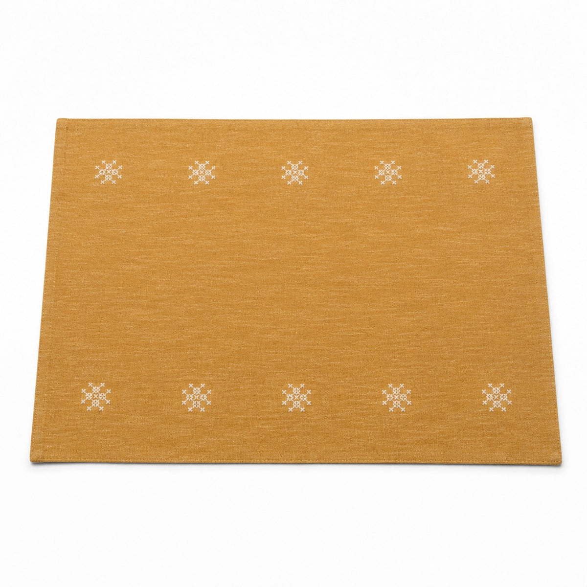 Mustard ochre placemat with small white embroidered rosette motifs in border rows, warm table linen by Primeval