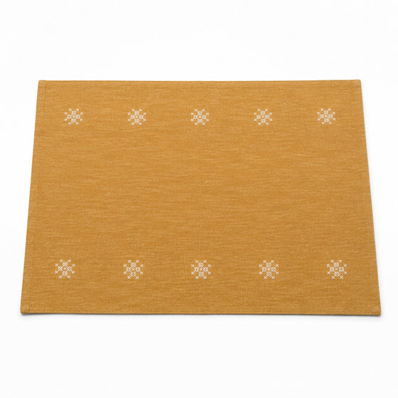 Mustard ochre placemat with small white embroidered rosette motifs in border rows, warm table linen by Primeval