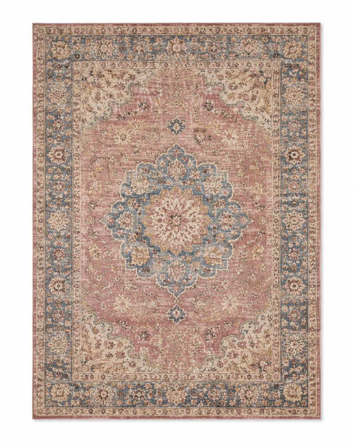 Softly distressed Persian-inspired area rug with dusty pink field, blue floral medallion and border, and warm beige accents