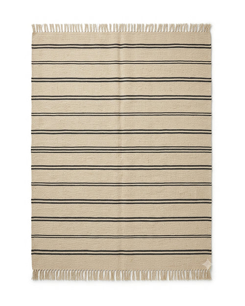 Beige and black minimal stripe flatweave-style rug with fringe by Primeval