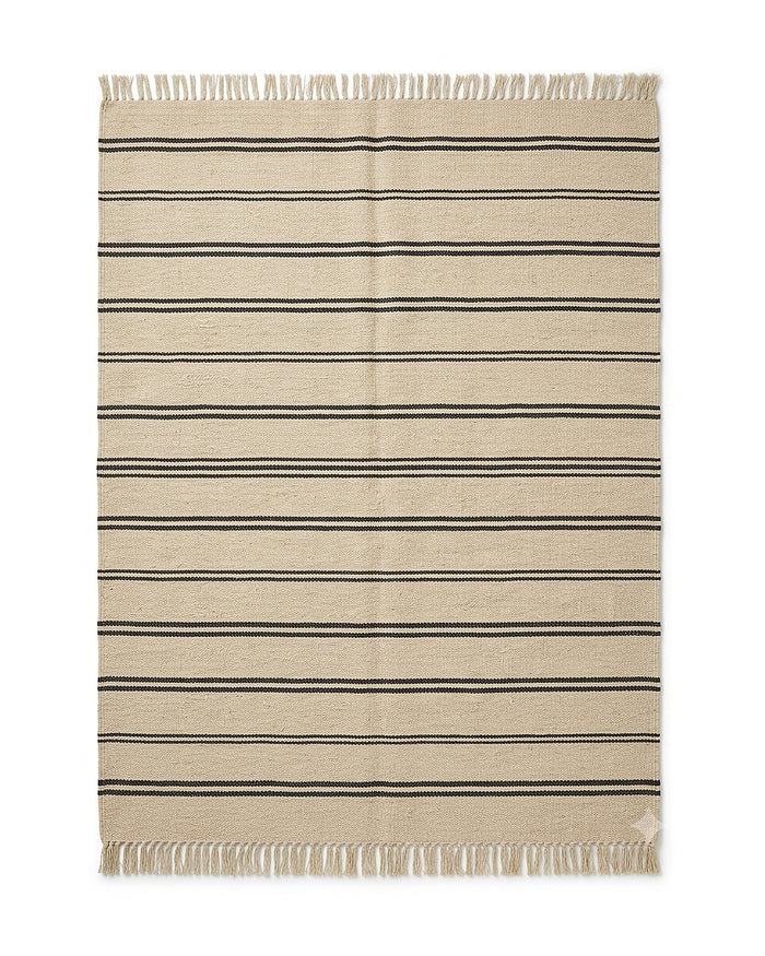 Beige and black minimal stripe flatweave-style rug with fringe by Primeval