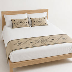 Beige and black tribal diamond bed runner styled on white bedding for wholesale boutique, resort and home textile sourcing