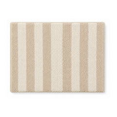 Beige and cream striped plush bath mat on white background