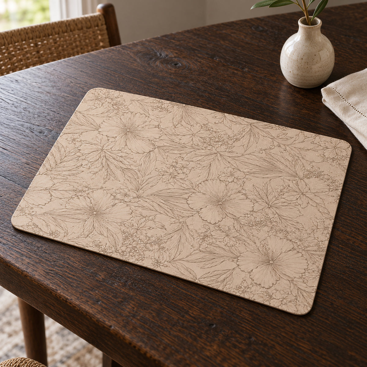 Beige rectangular placemat with delicate embossed floral pattern on a wooden table