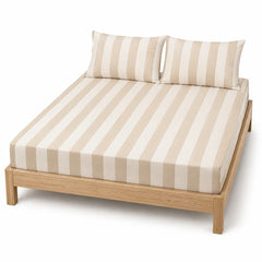Beige and ivory broad-stripe bed sheet set with matching pillowcases on a wooden bed