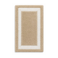 Beige and ivory framed plush bath mat on white background