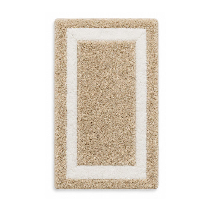 Beige and ivory framed plush bath mat on white background