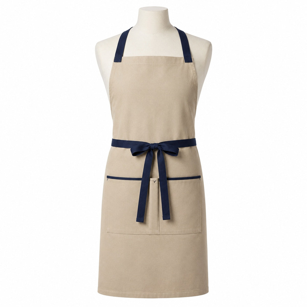 Primeval beige chef apron with navy cross-back straps and pocket trim displayed on a dress form