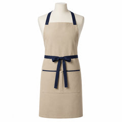 Primeval beige chef apron with navy cross-back straps and pocket trim displayed on a dress form