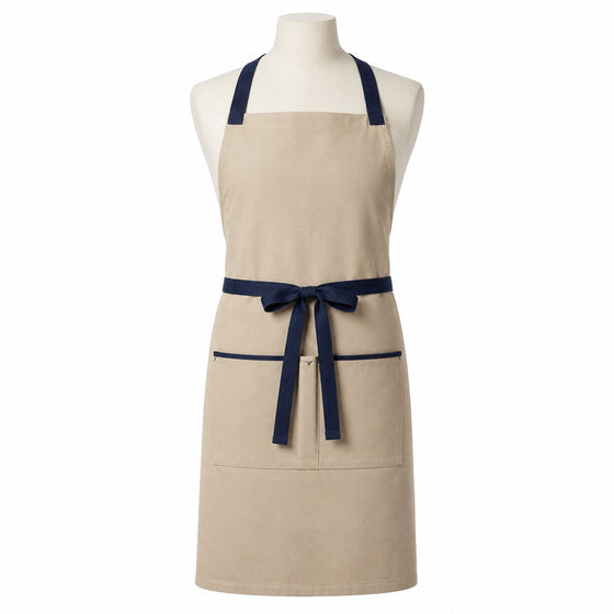 Primeval beige chef apron with navy cross-back straps and pocket trim displayed on a dress form