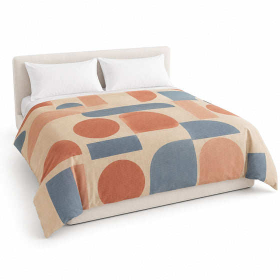 Primeval beige terracotta and dusty blue Bauhaus-inspired duvet cover displayed on a styled bed against a clean white studio background
