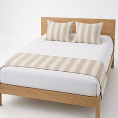 Beige wide-stripe bed runner styled across white bedding for wholesale hotel, resort and private-label bedroom collections