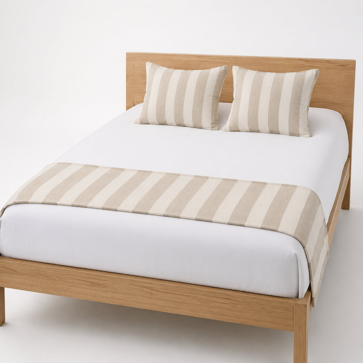 Beige wide-stripe bed runner styled across white bedding for wholesale hotel, resort and private-label bedroom collections