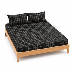 Black and ivory windowpane bed sheet set with matching pillowcases on a wooden bed