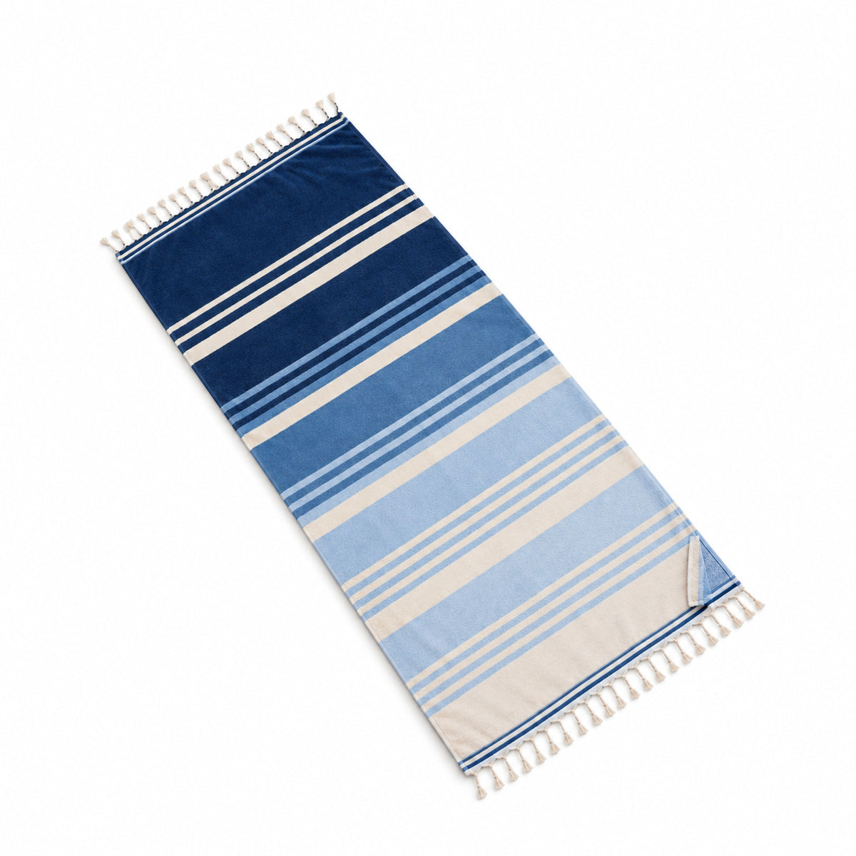 Blue ombre striped fringed beach towel on a white background.