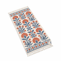 Ivory fringed beach towel with blue and terracotta botanical floral print.