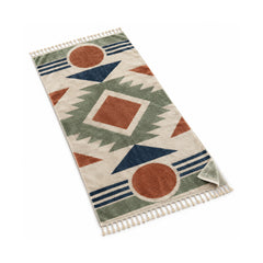 Natural fringed beach towel with terracotta, navy and sage geometric motifs.