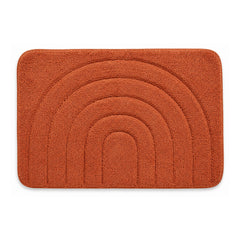 Burnt orange concentric arch textured bath mat on white background