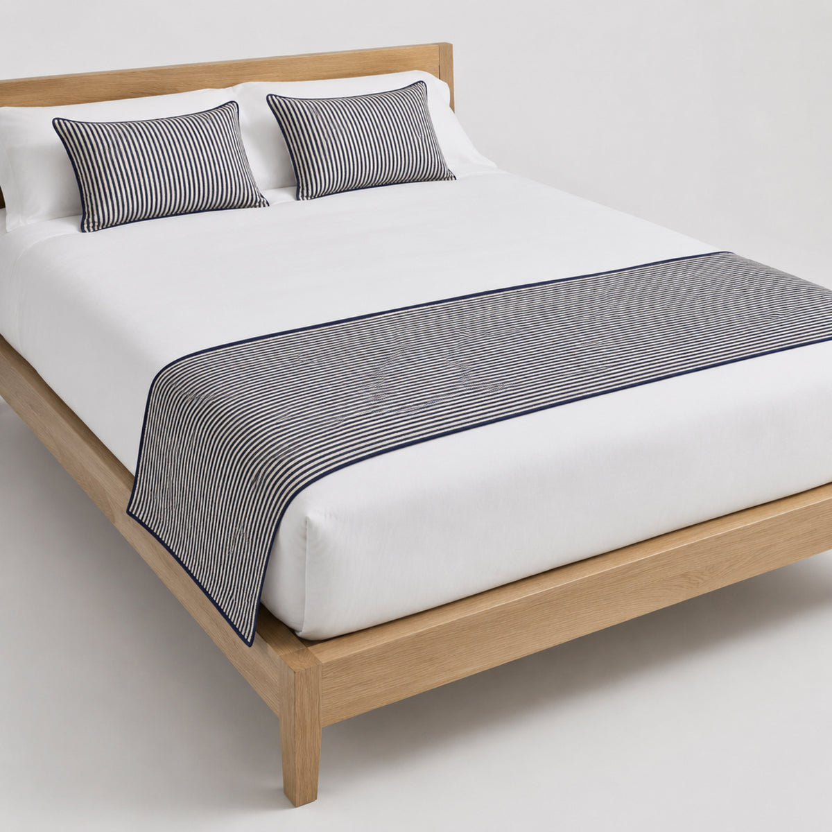Charcoal grey solid bed runner styled on white bedding for wholesale hospitality, modern hotel and private-label sourcing