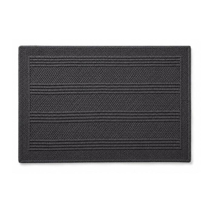 Charcoal woven bath mat with linear texture on white background