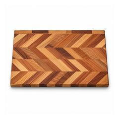 Rectangular wooden cutting board with intricate interlocking chevron V-shaped bands in honey-gold, reddish-brown and dark walnut-like shades