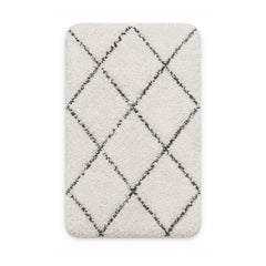 Cream shag bath mat with charcoal trellis pattern on white background