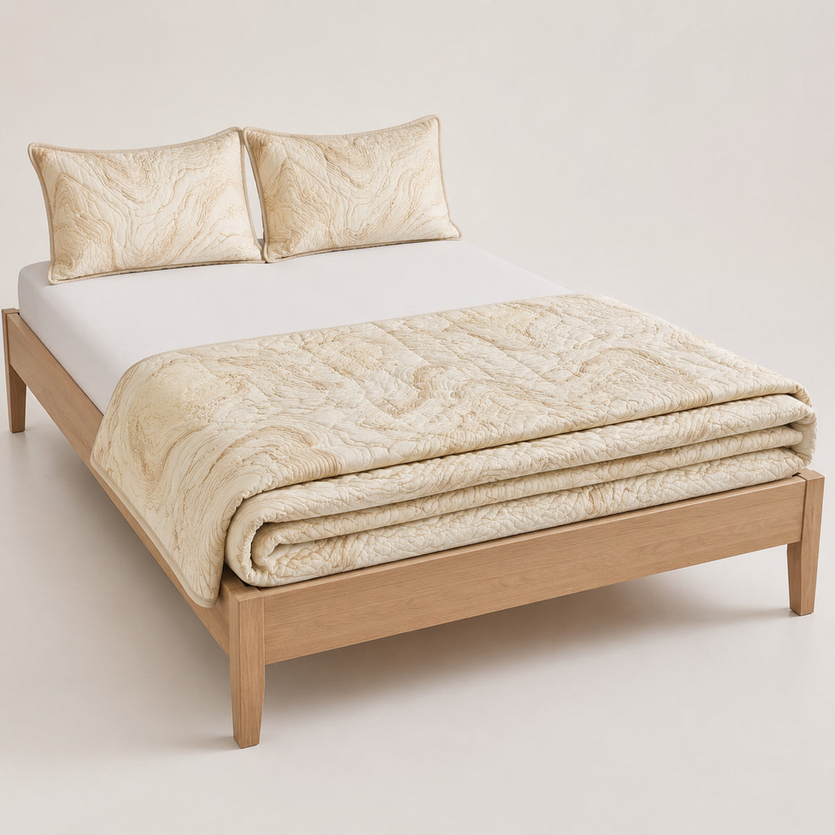 Cream organic contour cotton quilt, folded with matching pillows for wholesale bedding sourcing