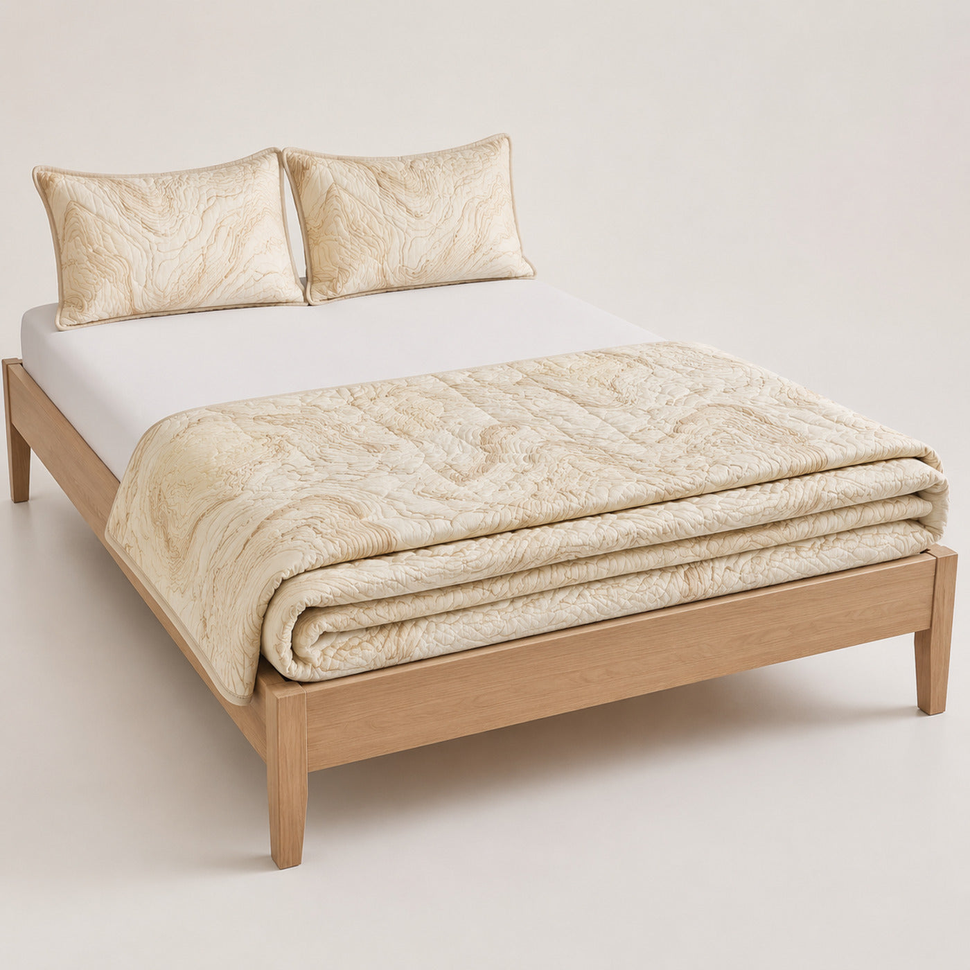 Cream organic contour cotton quilt, folded with matching pillows for wholesale bedding sourcing