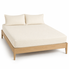 Cream waffle-texture bed sheet set with matching pillowcases on a wooden bed