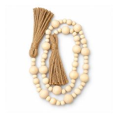 Cream wooden bead garland with mixed-size round beads arranged in loose loops and natural-fiber tassels at both ends