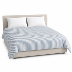 Primeval dusty blue cream narrow stripe duvet cover displayed on a styled bed against a clean white studio background