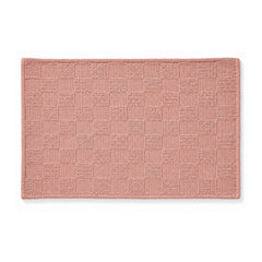 Dusty rose woven checkerboard bath mat on white background