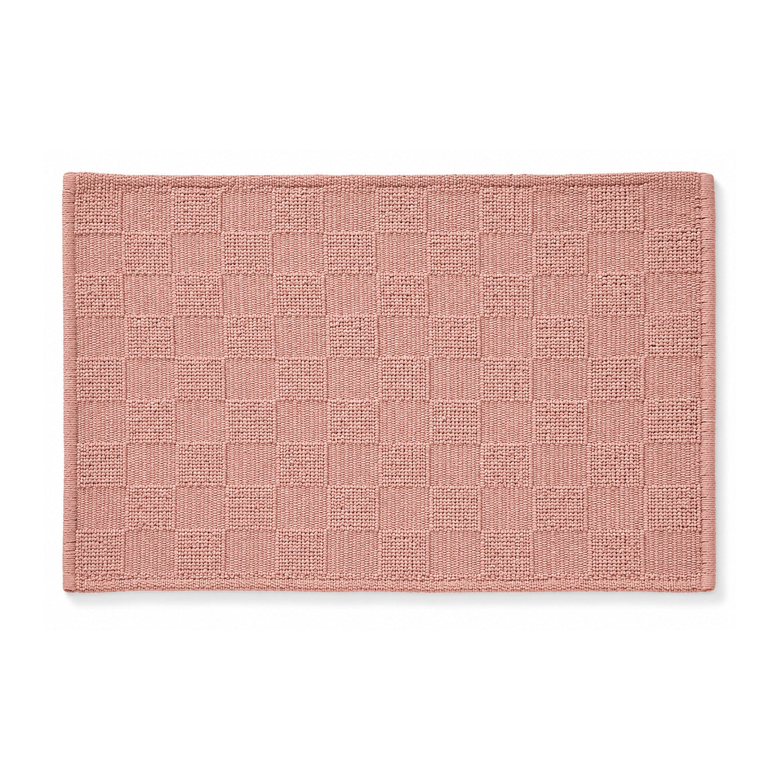 Dusty rose woven checkerboard bath mat on white background
