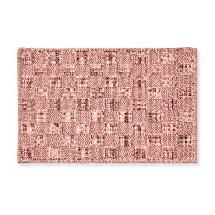 Dusty rose woven checkerboard bath mat on white background