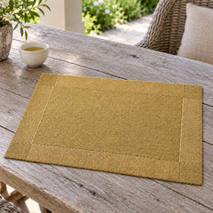 Champagne gold rectangular placemat with fine woven-look texture and defined border on a weathered wood table