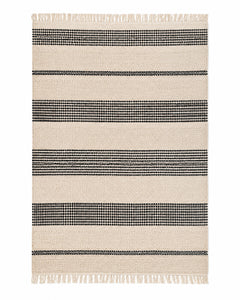 Black and ivory handwoven cotton rug with bold horizontal stripes and fringe