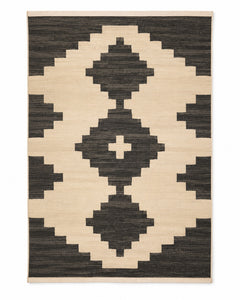 Black and ivory handwoven cotton rug with bold tribal geometric motif