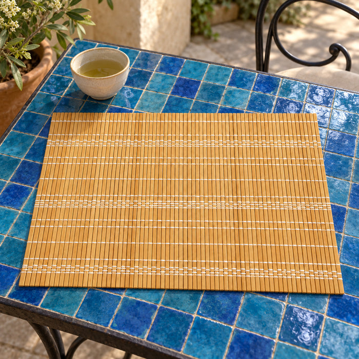 Honey golden rectangular placemat with many fine bamboo-slat-looking parallel strips on a vivid blue mosaic tiled table