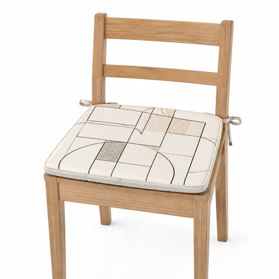 Primeval ivory and black linear grid dining chair pad with tie straps on wooden dining chair