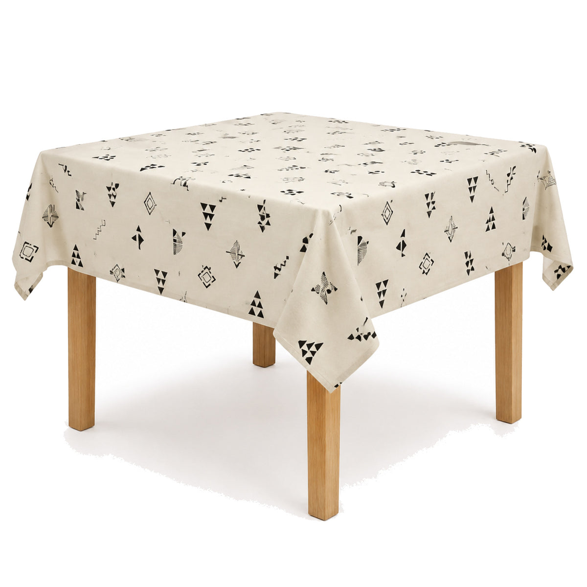 Primeval ivory black Scandinavian geometric print tablecloth displayed on a square dining table