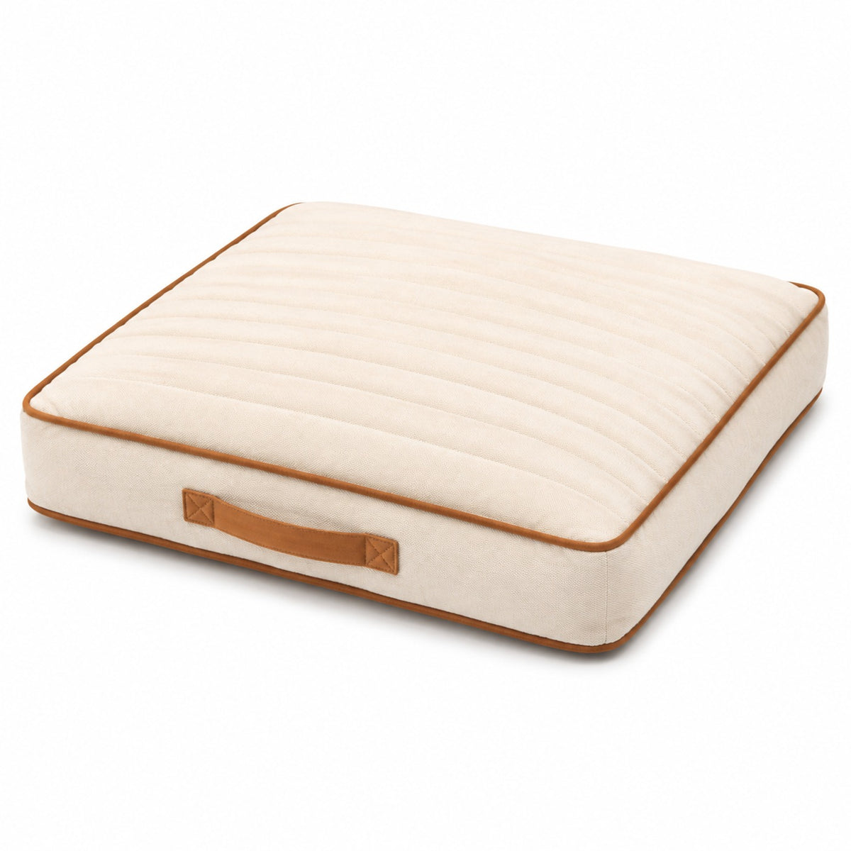 Ivory square channel-quilted floor cushion with tan piping and carry handle on white background