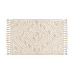 Ivory woven diamond bath mat with fringe on white background